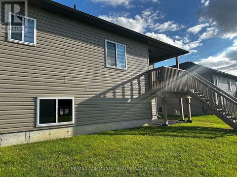 A house with a grey siding and a wooden deck.