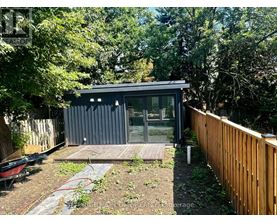 A small house with a glass door and a wooden deck.