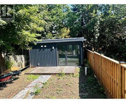 A small house with a glass door and a wooden deck.