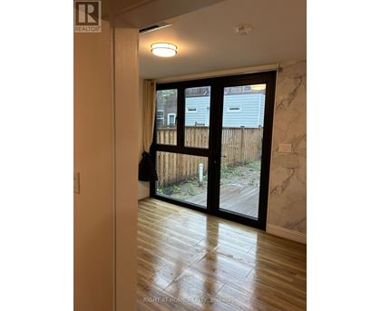 A room with a sliding glass door leading to a backyard.