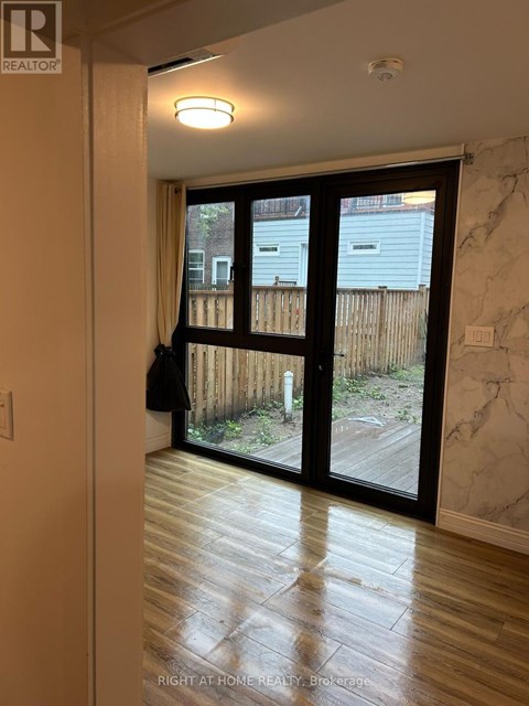 A room with a sliding glass door leading to a backyard.