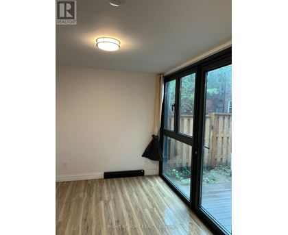 A room with a sliding glass door and a black jacket hanging on the door.