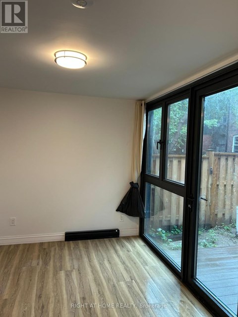 A room with a sliding glass door and a black jacket hanging on the door.