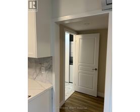 A white door is in a hallway with a marble counter top.