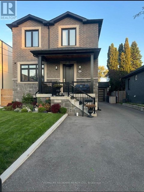 A house with a grey front yard and a black gate.
