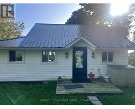 A small white house with a black door and windows is for sale in Brokerage.