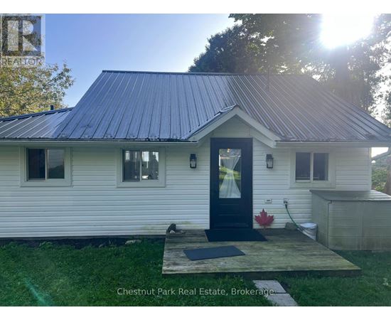 A small white house with a black door and windows is for sale in Brokerage.