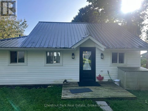 A small white house with a black door and windows is for sale in Brokerage.