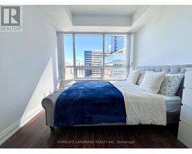 A bedroom with a large bed and a view of the city.
