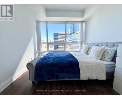A bedroom with a large bed and a view of the city.