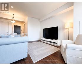 A living room with a blue couch, a white chair, and a flat screen TV.