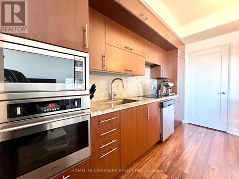 A kitchen with wooden cabinets and a stainless steel oven.