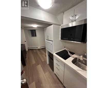 A kitchen with a stove top oven, microwave, and sink.