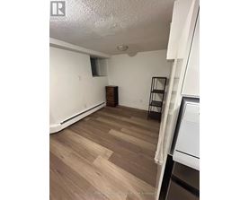 A room with wooden flooring and white walls.