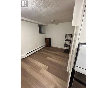 A room with wooden flooring and white walls.