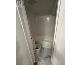 A white toilet in a small bathroom.