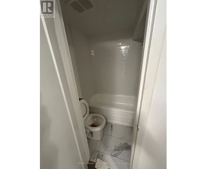 A white toilet in a small bathroom.