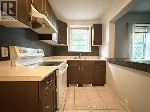 A kitchen with brown cabinets and a white dishwasher.