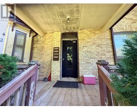 A black door is on the left side of a brick building.