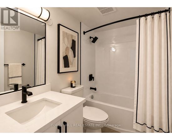 A white bathroom with a sink, toilet, and shower.