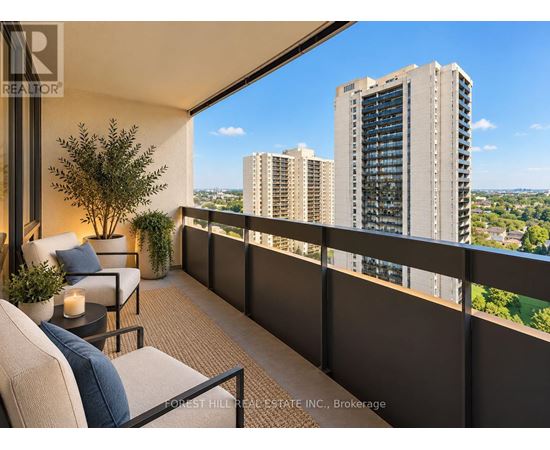 A balcony with a table and chairs overlooking a cityscape.