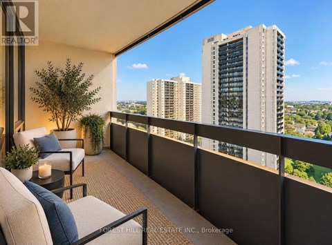 A balcony with a table and chairs overlooking a cityscape.