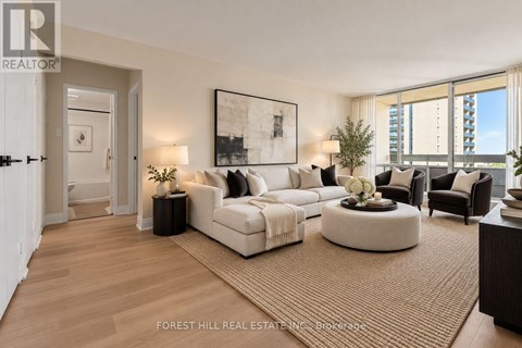 A living room with a large couch and a painting on the wall.