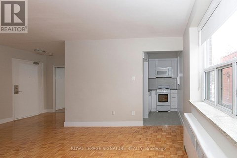 A spacious room with a kitchen area in the back.