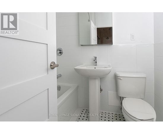 A white bathroom with a sink, toilet and mirror.