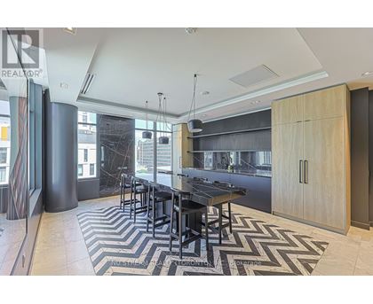 A modern kitchen with a black table and chairs.