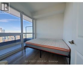 A bedroom with a large bed and a view of the city.