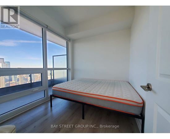 A bedroom with a large bed and a view of the city.