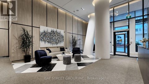 A modern office lobby with a large abstract painting on the wall.
