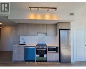 A kitchen with a blue dishwasher and stainless steel refrigerator.
