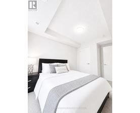 A bedroom with a bed, nightstand, and two doors.