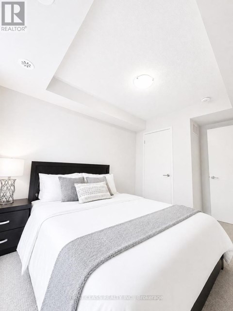 A bedroom with a bed, nightstand, and two doors.