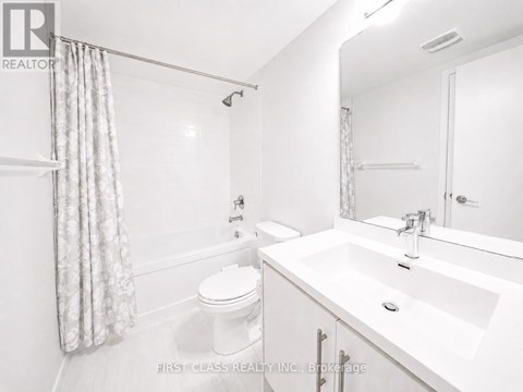 A white bathroom with a toilet, sink, and shower.