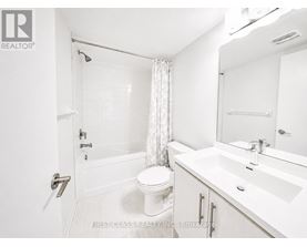 A white bathroom with a toilet, sink, and bathtub.