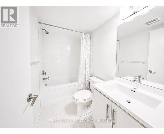 A white bathroom with a toilet, sink, and bathtub.