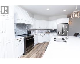 A modern kitchen with white cabinets and a stainless steel refrigerator.