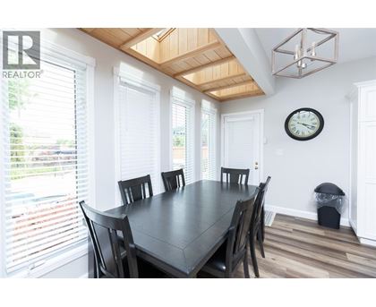 A dining room with a table and chairs.