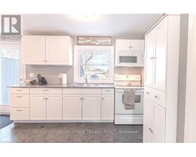 A white kitchen with a sign that says "Sunday Dinner".