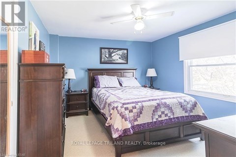 A bedroom with a bed, nightstand, and a dresser.