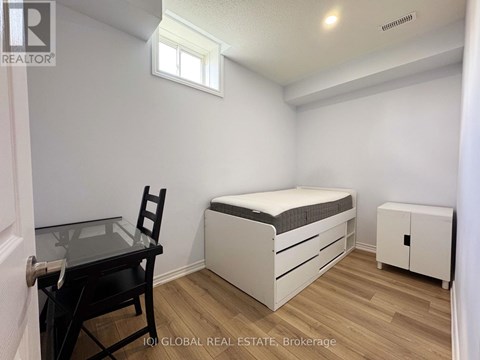 A bedroom with a bed, chair, and cabinet.