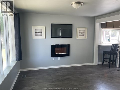 A living room with a fireplace and a television mounted on the wall.