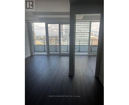 A room with a view of the city through large windows.