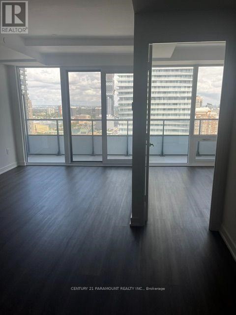 A room with a view of the city through large windows.