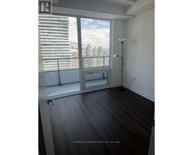 A room with a large window overlooking a cityscape.