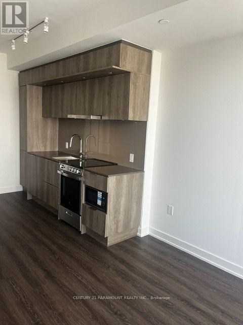 A modern kitchen with wooden cabinets and a stainless steel sink.