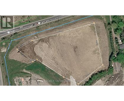 A satellite image shows a large open field with a road running through it.